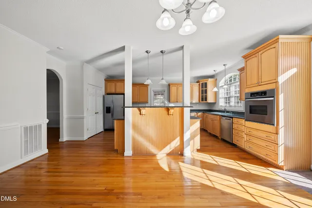 a view of a kitchen with stainless steel appliances granite countertop a refrigerator and a stove top oven