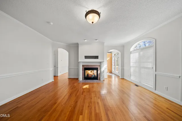 a view of a livingroom with a fireplace wooden floor and window