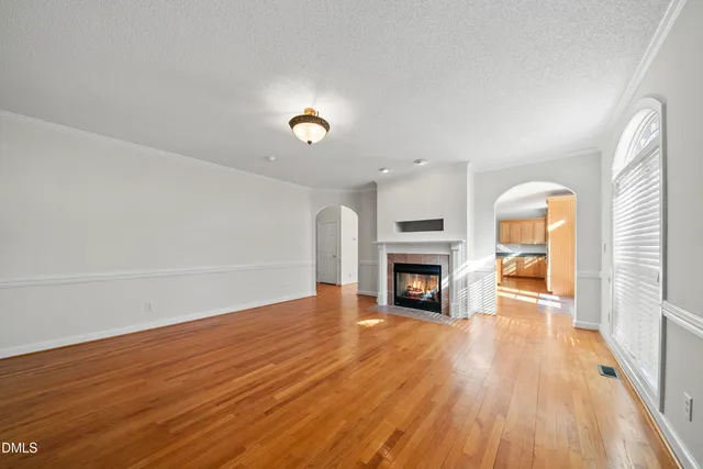an empty room with wooden floor and fireplace