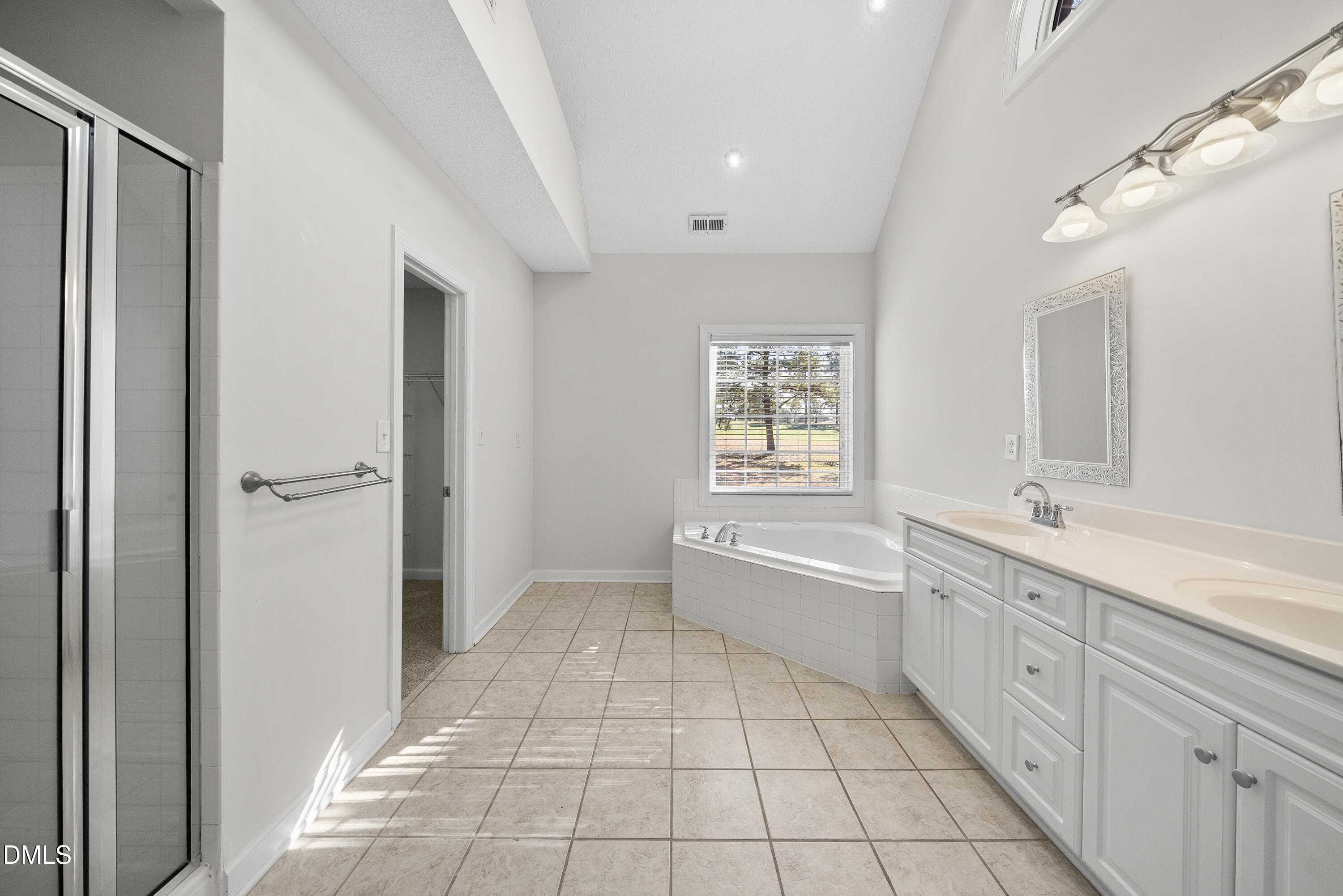 5833 Mockingbird Lane Sanford, NC 27332 - Photo 25 of 34 a spacious bathroom with a granite countertop sink a mirror and a bathtub