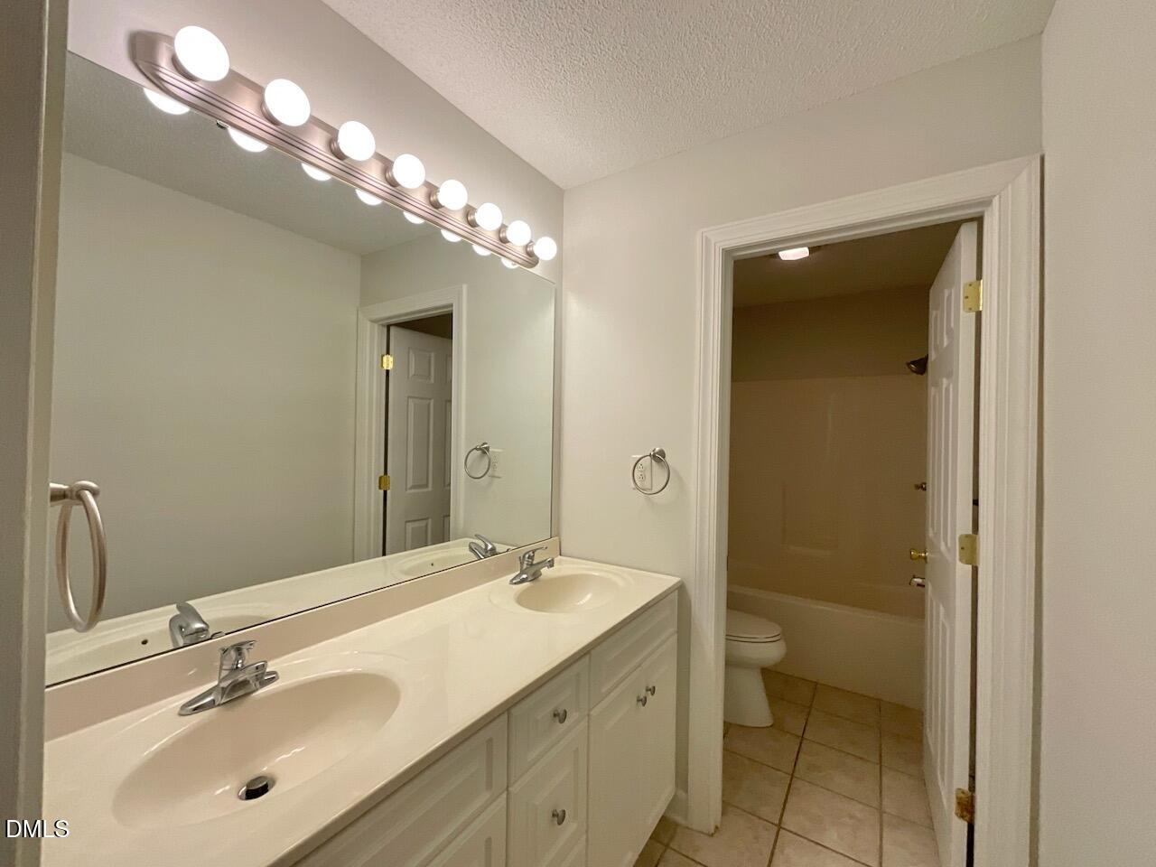 5833 Mockingbird Lane Sanford, NC 27332 - Photo 30 of 34 a bathroom with a sink double vanity and a mirror