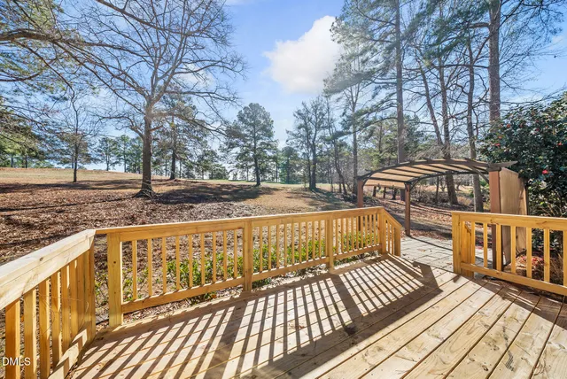 a view of a wooden deck with large trees