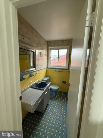 a bathroom with a sink a toilet and mirror