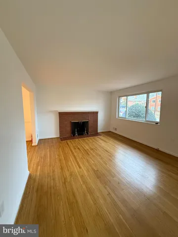 a view of empty room with wooden floor and window