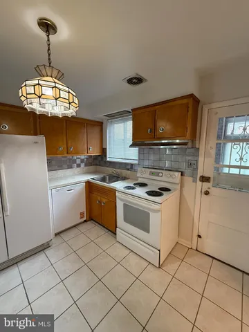 a kitchen with a stove sink and cabinets