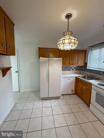 a kitchen with stainless steel appliances a sink a stove a refrigerator and cabinets