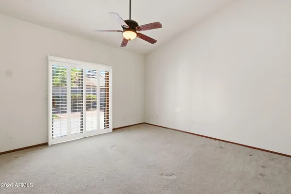 an empty room with closet and a chandelier fan
