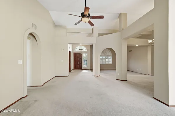an empty room with a ceiling fan and a window