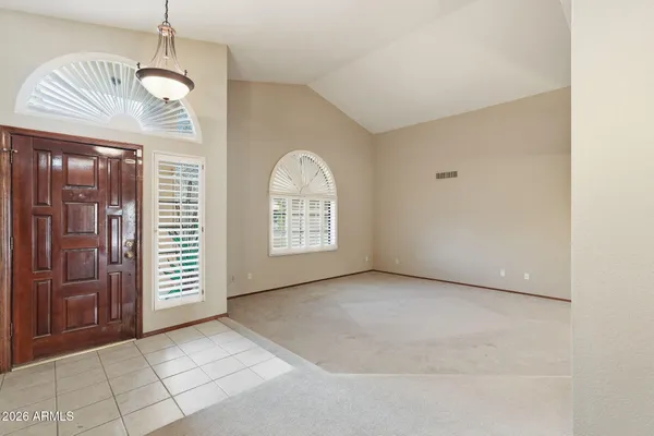 an empty room with windows and chandelier