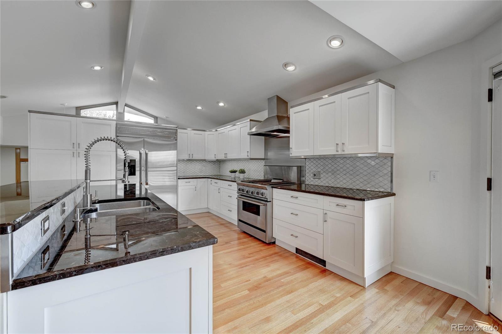 5140 Juniper Street Bow Mar, CO 80123 - Photo 16 of 40 a kitchen with granite countertop stainless steel appliances and wooden cabinets