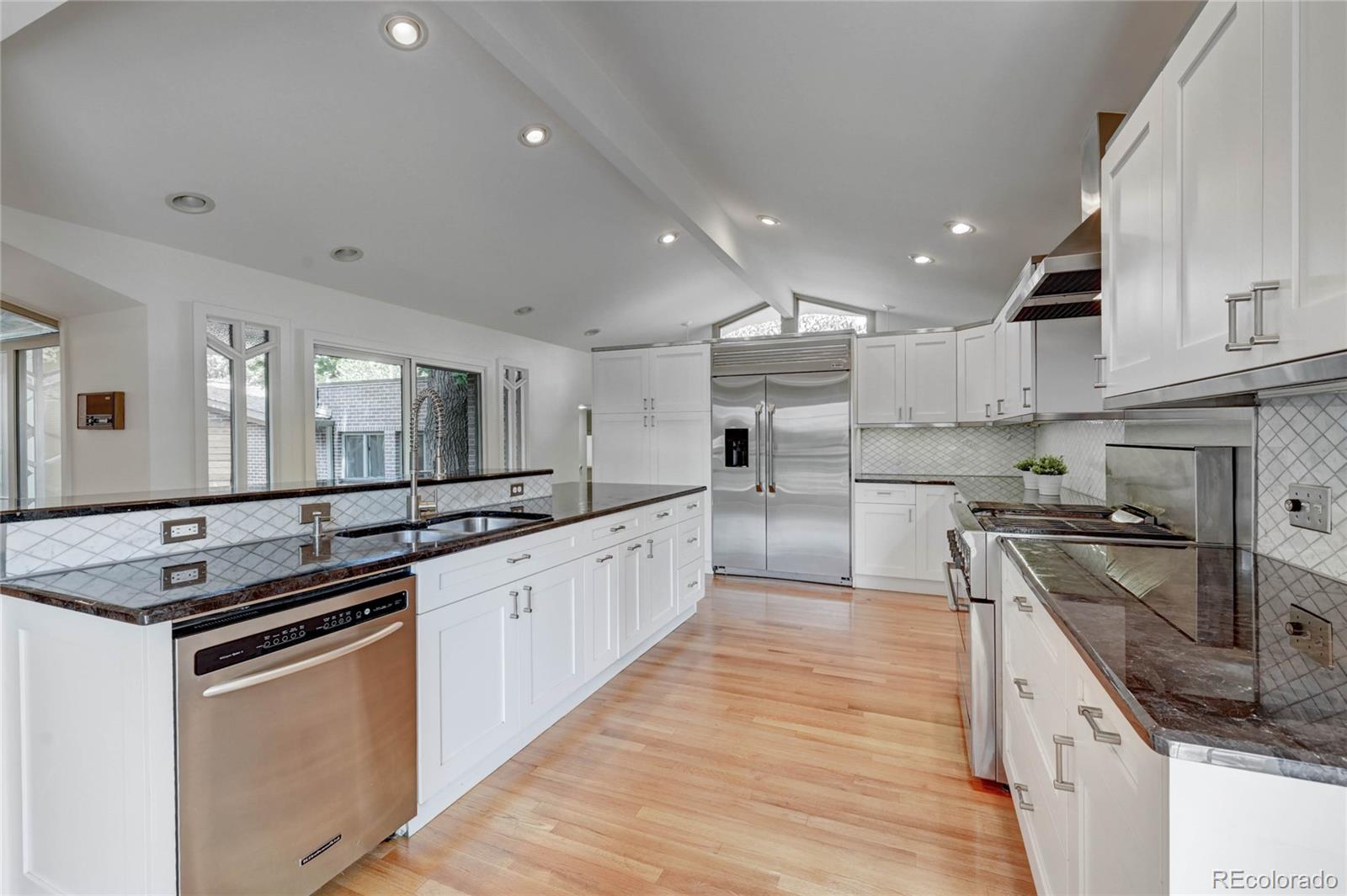 5140 Juniper Street Bow Mar, CO 80123 - Photo 17 of 40 a kitchen with stainless steel appliances granite countertop counter space a sink and cabinets