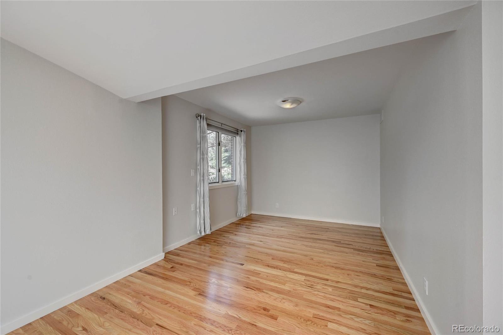 5140 Juniper Street Bow Mar, CO 80123 - Photo 30 of 40 a view of an empty room with wooden floor and a window