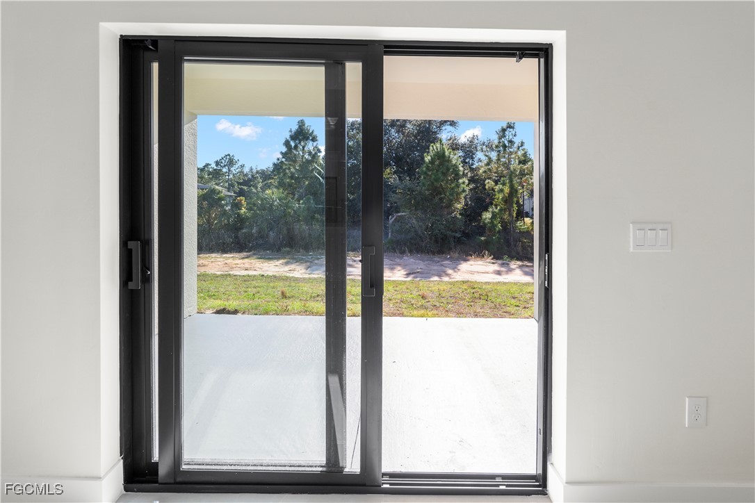 4649-4651 24th Street Southwest Lehigh Acres, FL 33973 - Photo 27 of 29 a view of a glass door with a yard from a room