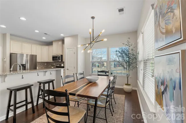 a kitchen with stainless steel appliances a dining table chairs and granite counter tops