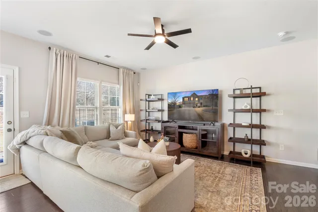 a living room with furniture a flat screen tv and a window