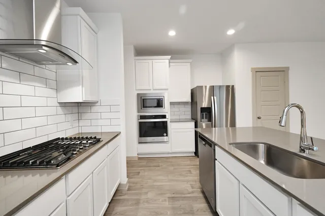a kitchen with refrigerator a sink and stove