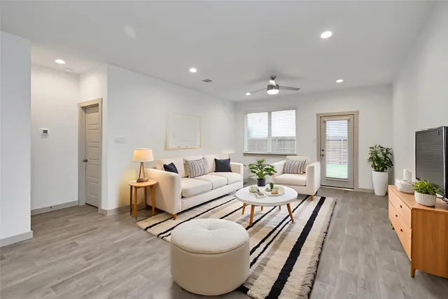 a living room with furniture a flat screen tv and a large window