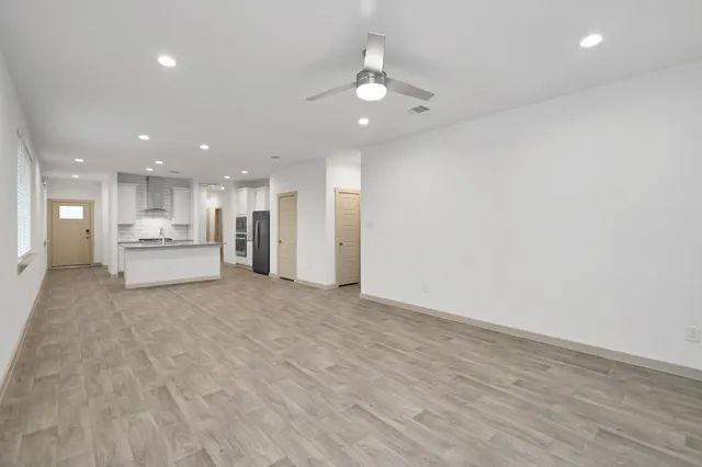 a view of an empty room with a kitchen