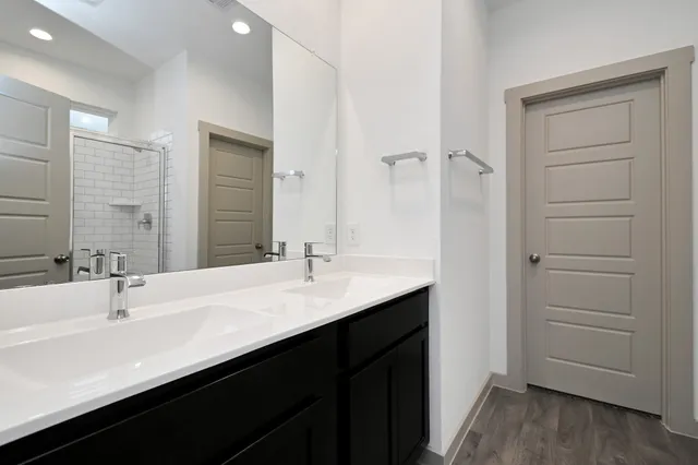 a bathroom with a double vanity sink a mirror and a bathtub