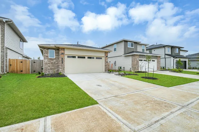 a view of a white house next to a yard with big trees