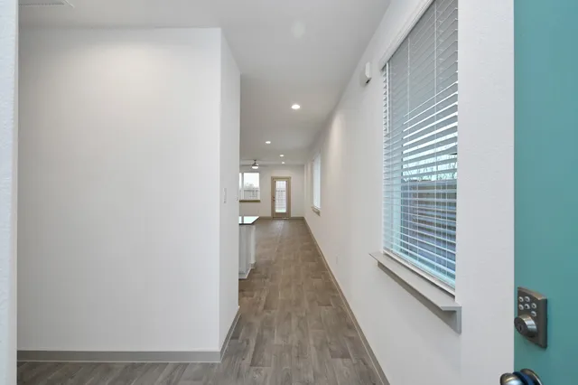a view of a hallway with wooden floor and staircase