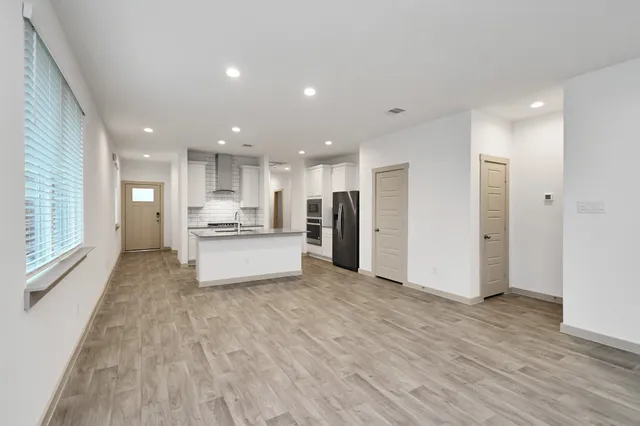 a open kitchen with white cabinets and a refrigerator