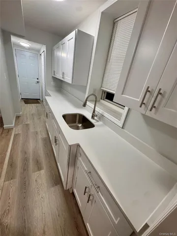 a kitchen with a sink and wooden floor