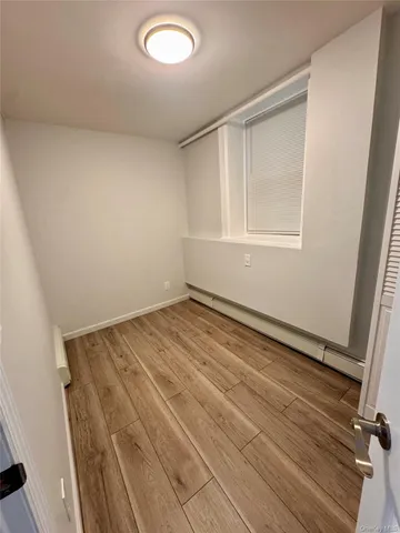 a view of a room with wooden floor and white walls