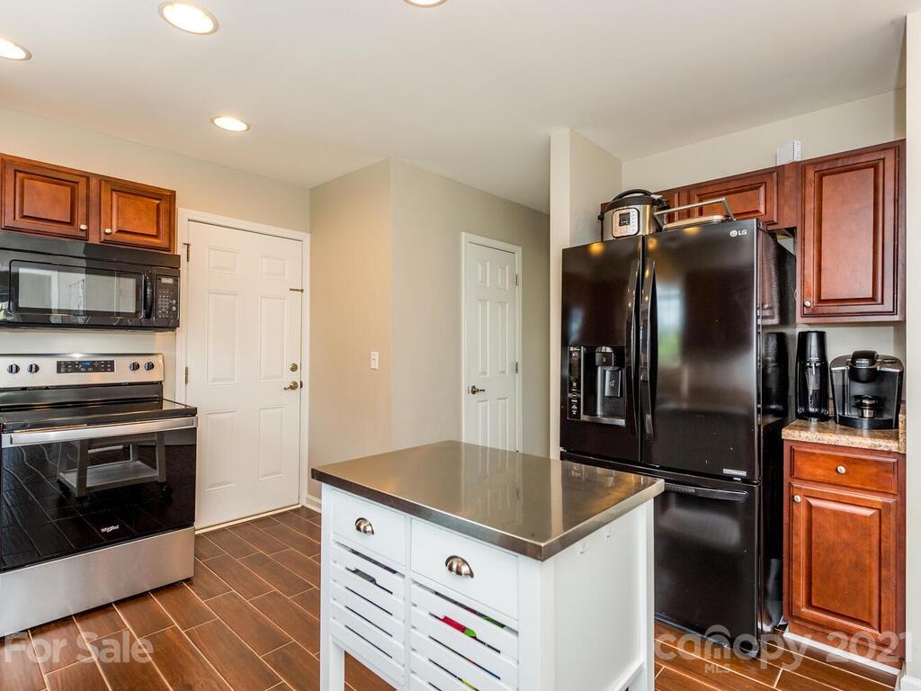 20 Roanoke Road Fletcher, NC 28732 - Photo 12 of 36 a kitchen with stainless steel appliances granite countertop a refrigerator a stove and a sink with wooden floor