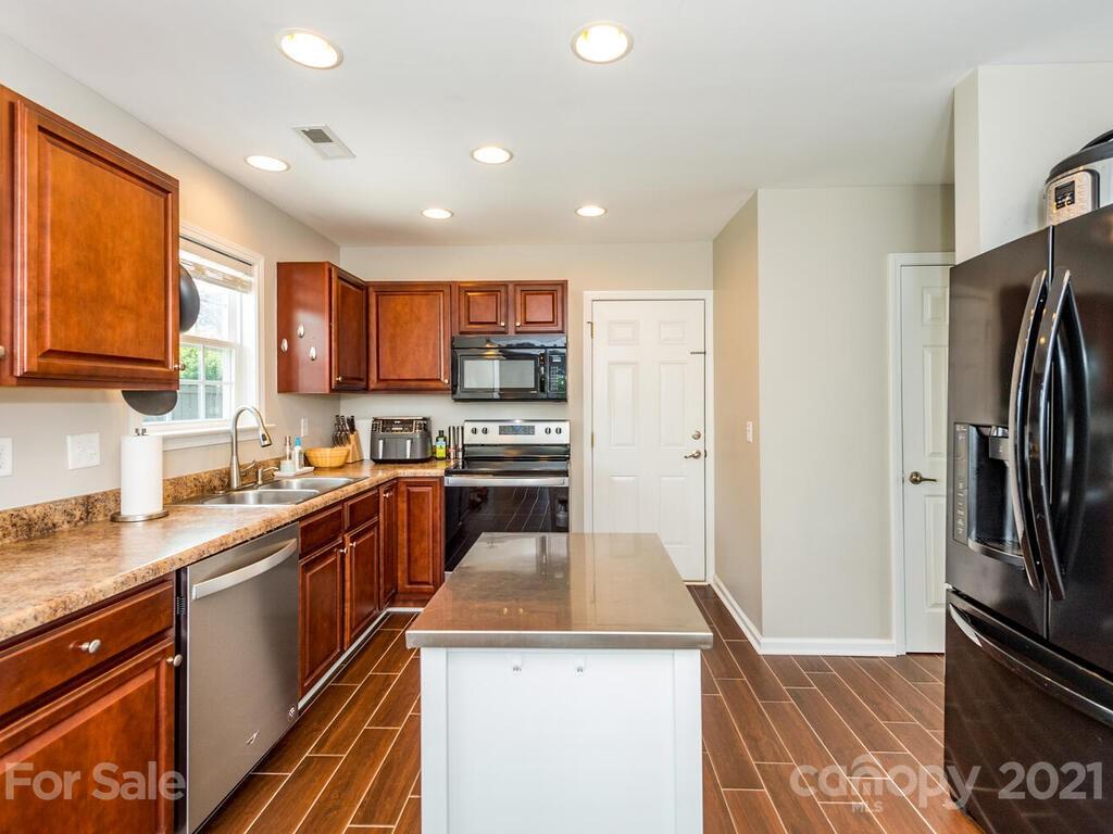 20 Roanoke Road Fletcher, NC 28732 - Photo 7 of 36 a kitchen with a sink a refrigerator and a stove top oven