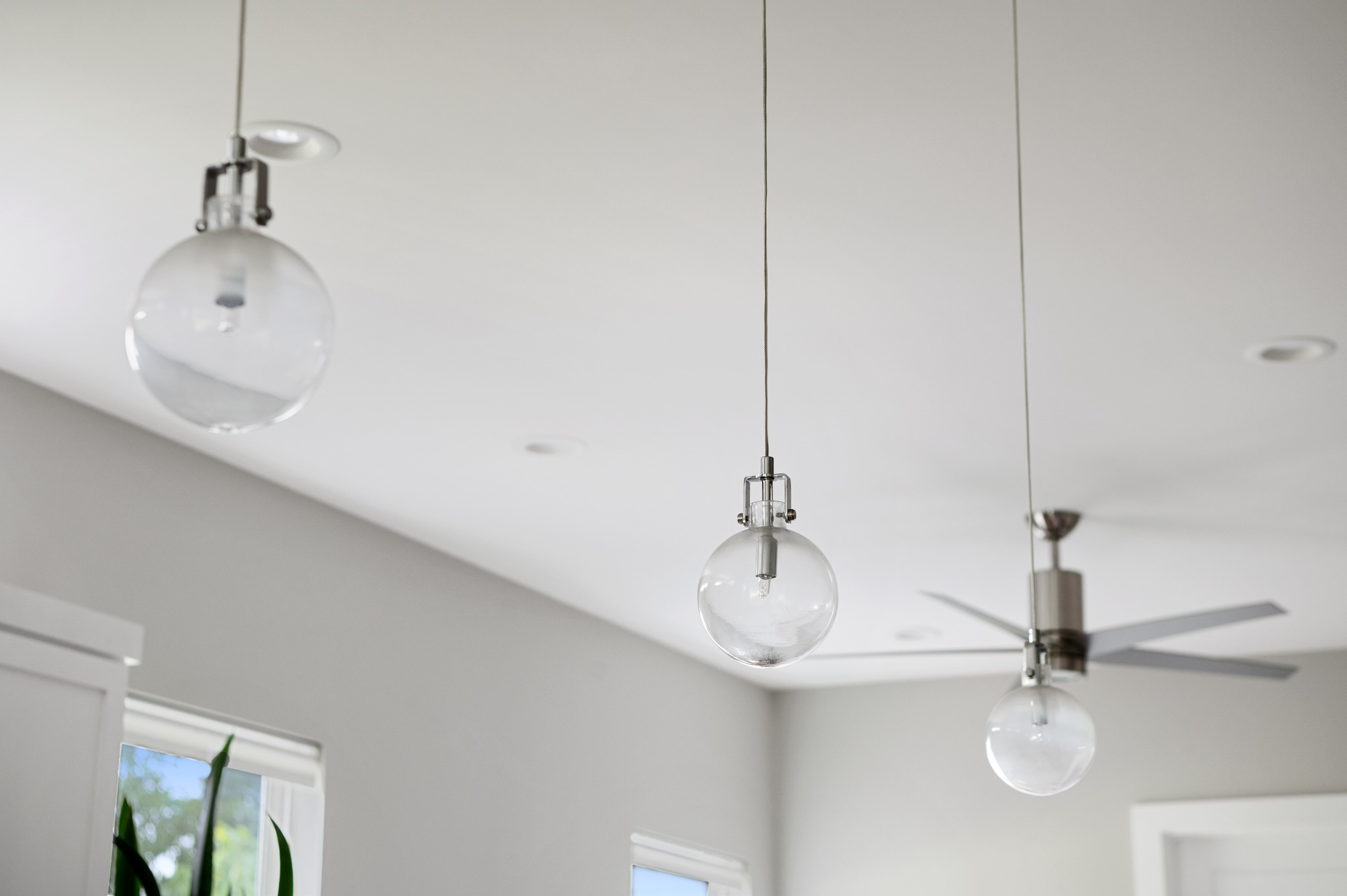 1103 Saucedo Street, Unit 1 Austin, TX 78721 - Photo 16 of 40 These modern pendant lights and sleek ceiling fan illuminate a bright, inviting interior space.