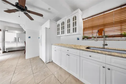a spacious bathroom with a granite countertop sink and washing machine