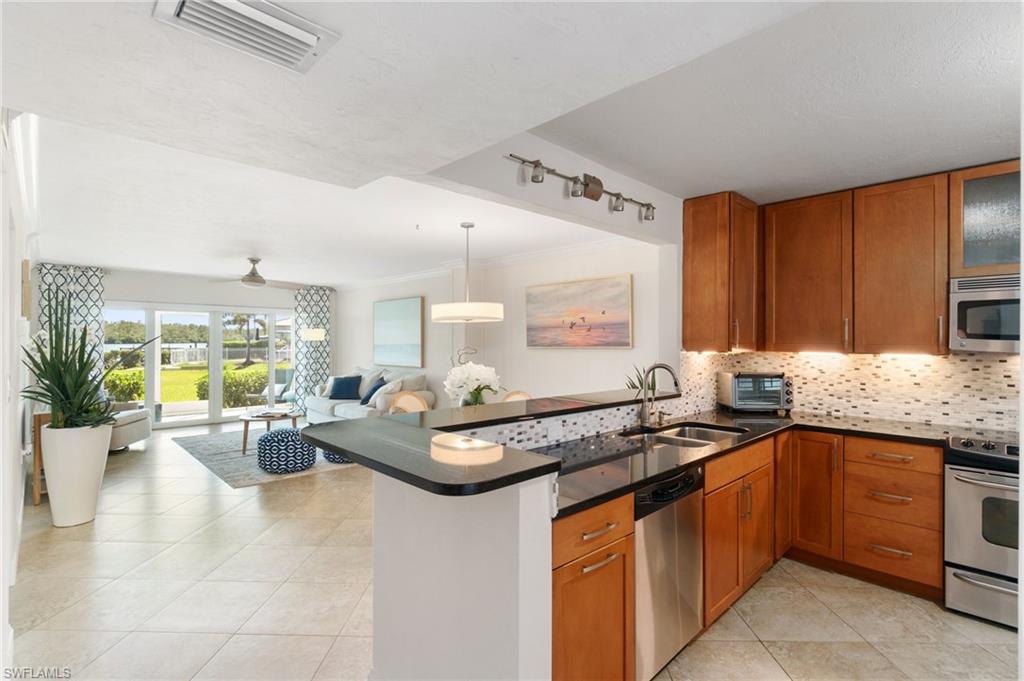 305 Goodlette-Frank Road, Unit C204 Naples, FL 34102 - Photo 8 of 16 a view of a kitchen with granite countertop a sink stove and cabinets