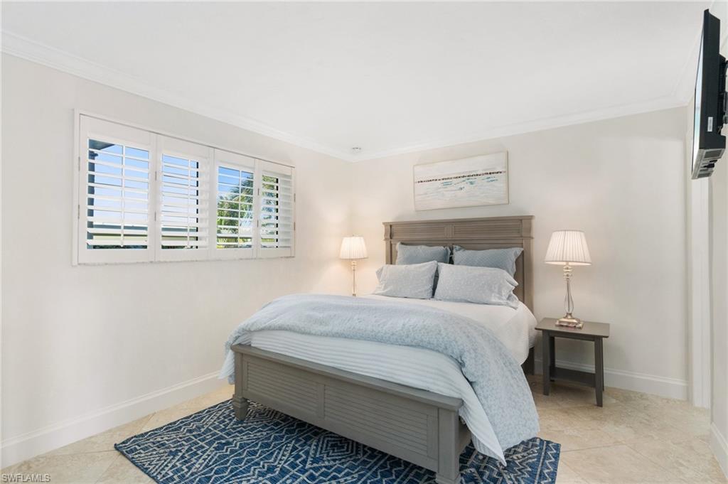 305 Goodlette-Frank Road, Unit C204 Naples, FL 34102 - Photo 10 of 16 a bedroom with a bed and a table