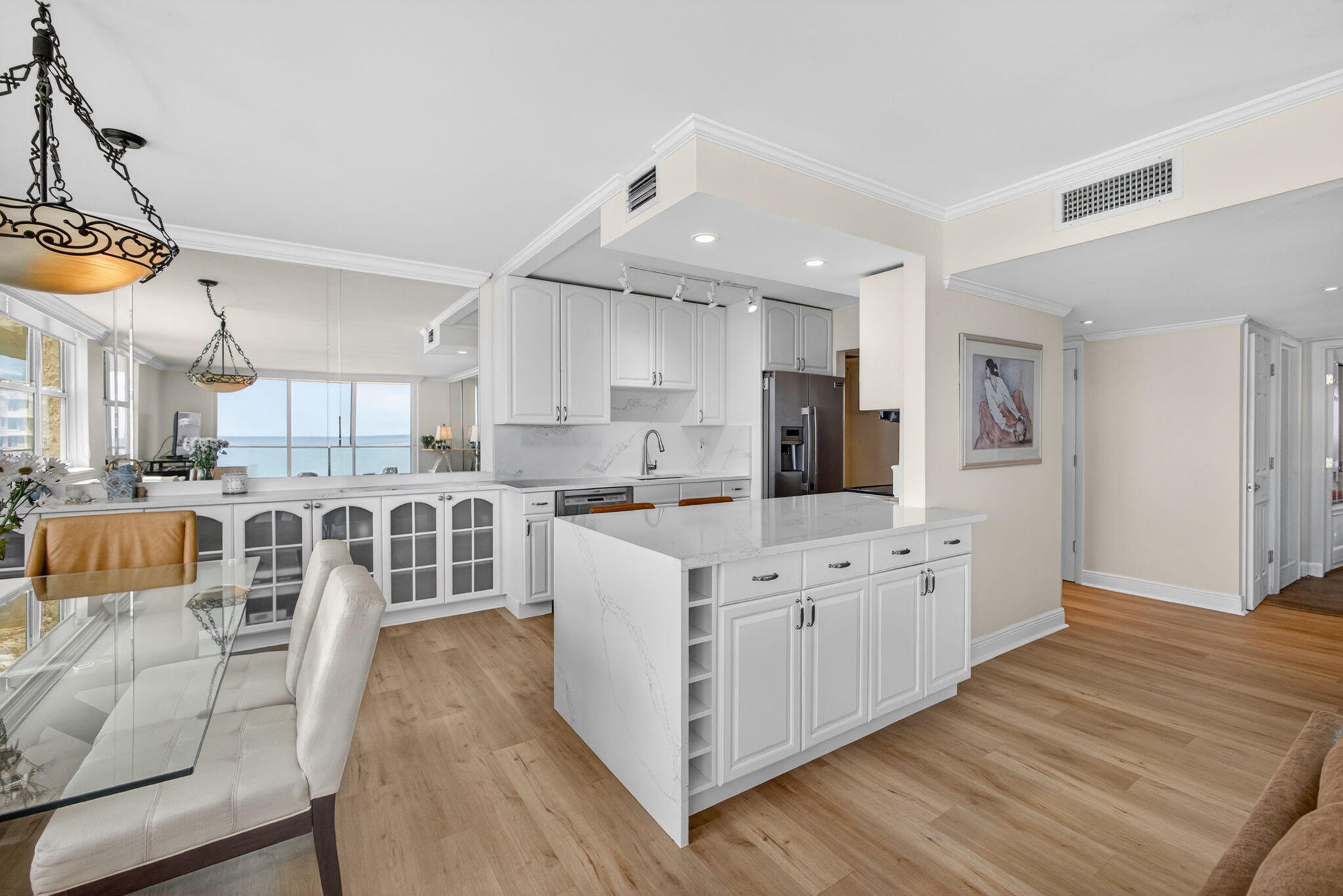 5440 North Ocean Drive, Unit 1006 Riviera Beach, FL 33404 - Photo 15 of 57 a large white kitchen with lots of counter space wooden floor and appliances