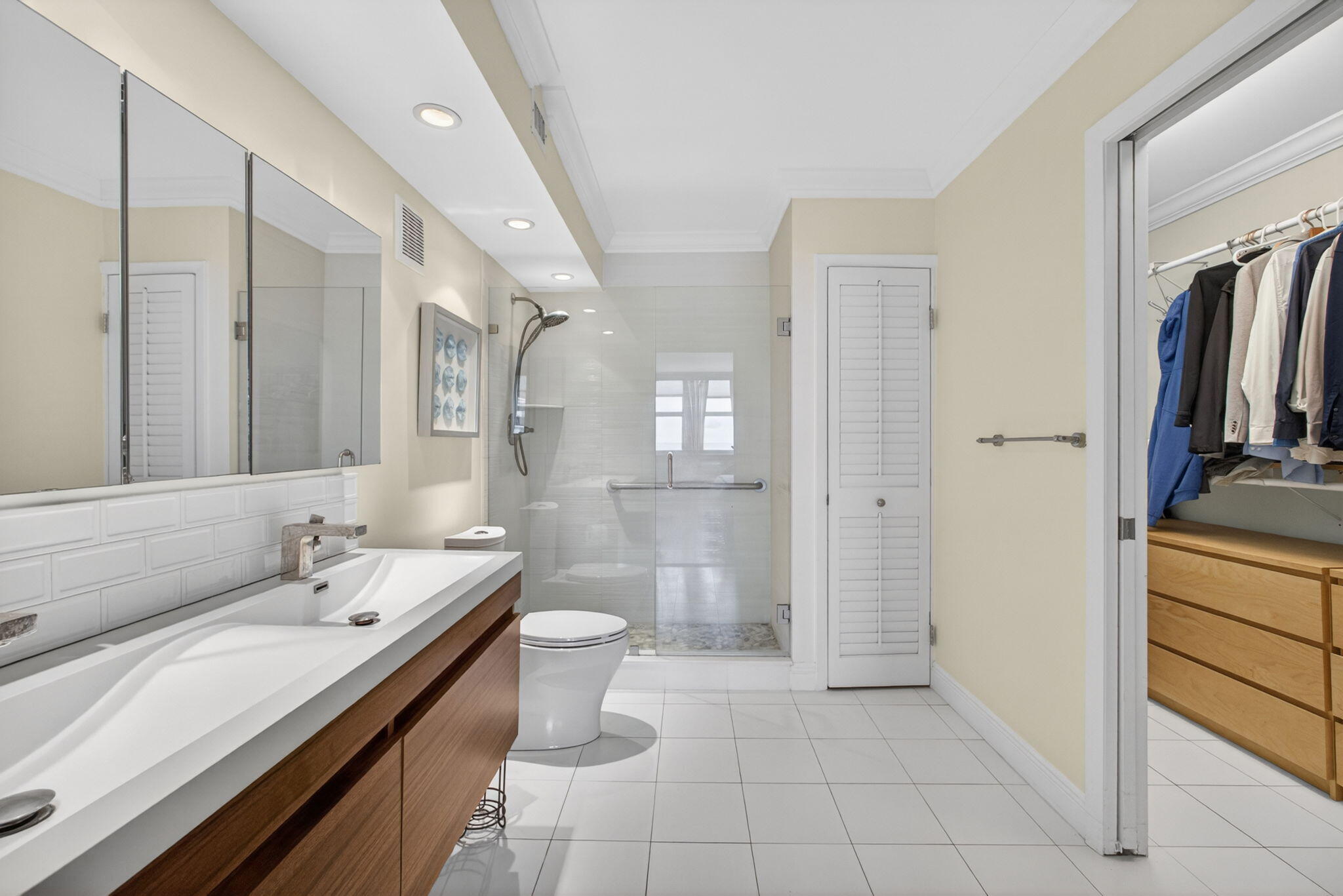 5440 North Ocean Drive, Unit 1006 Riviera Beach, FL 33404 - Photo 33 of 57 a spacious bathroom with a double vanity sink a large mirror and a shower