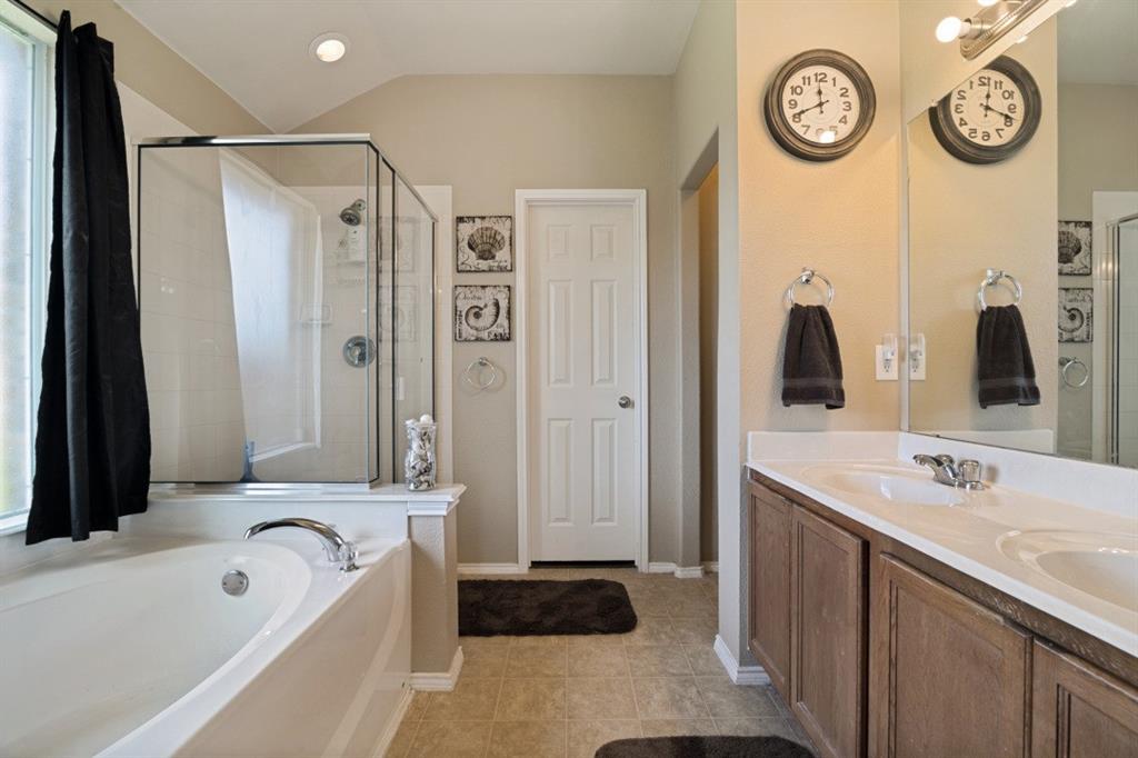 119 Robin Lane Forney, TX 75126 - Photo 15 of 27 Bathroom featuring a built-in soaking tub, a separate glass-enclosed shower, and a dual vanity with undermount sinks