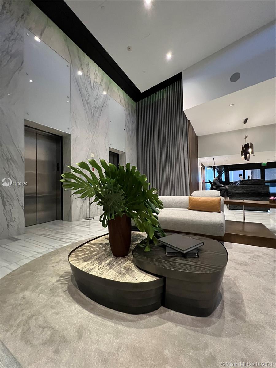 1100 Biscayne Boulevard, Unit 4504 Miami, FL 33132 - Photo 2 of 21 a living room with furniture and a potted plant