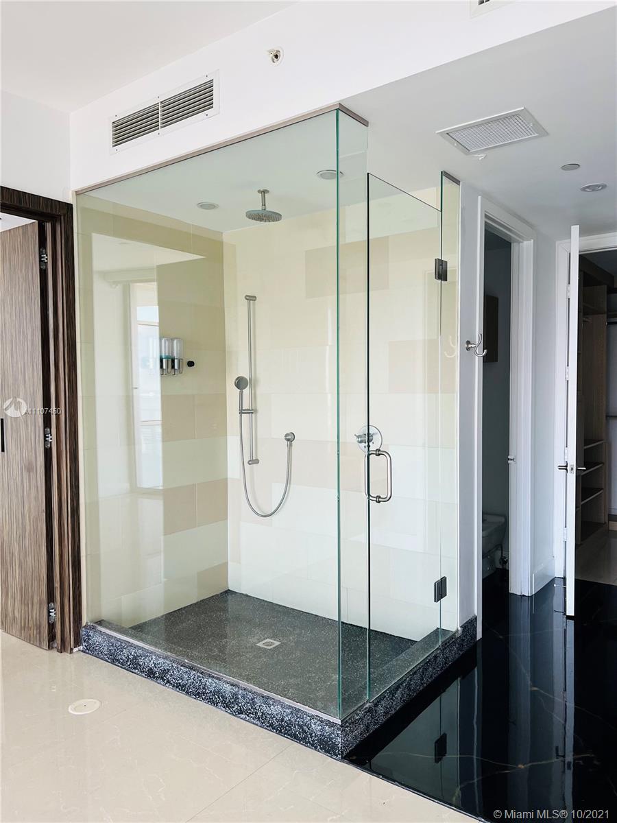 1100 Biscayne Boulevard, Unit 4504 Miami, FL 33132 - Photo 9 of 21 a bathroom with a glass shower door and a sink