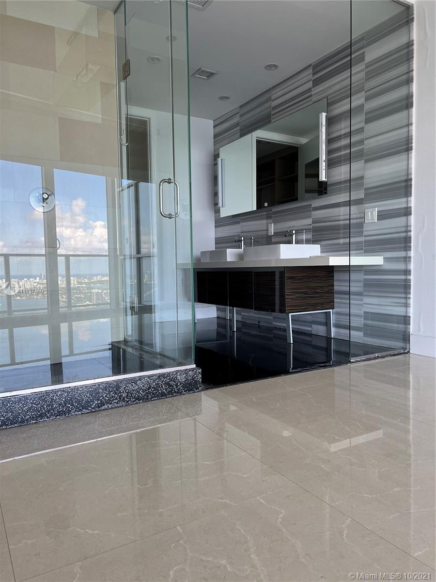1100 Biscayne Boulevard, Unit 4504 Miami, FL 33132 - Photo 10 of 21 a bathroom with a sink and a large mirror