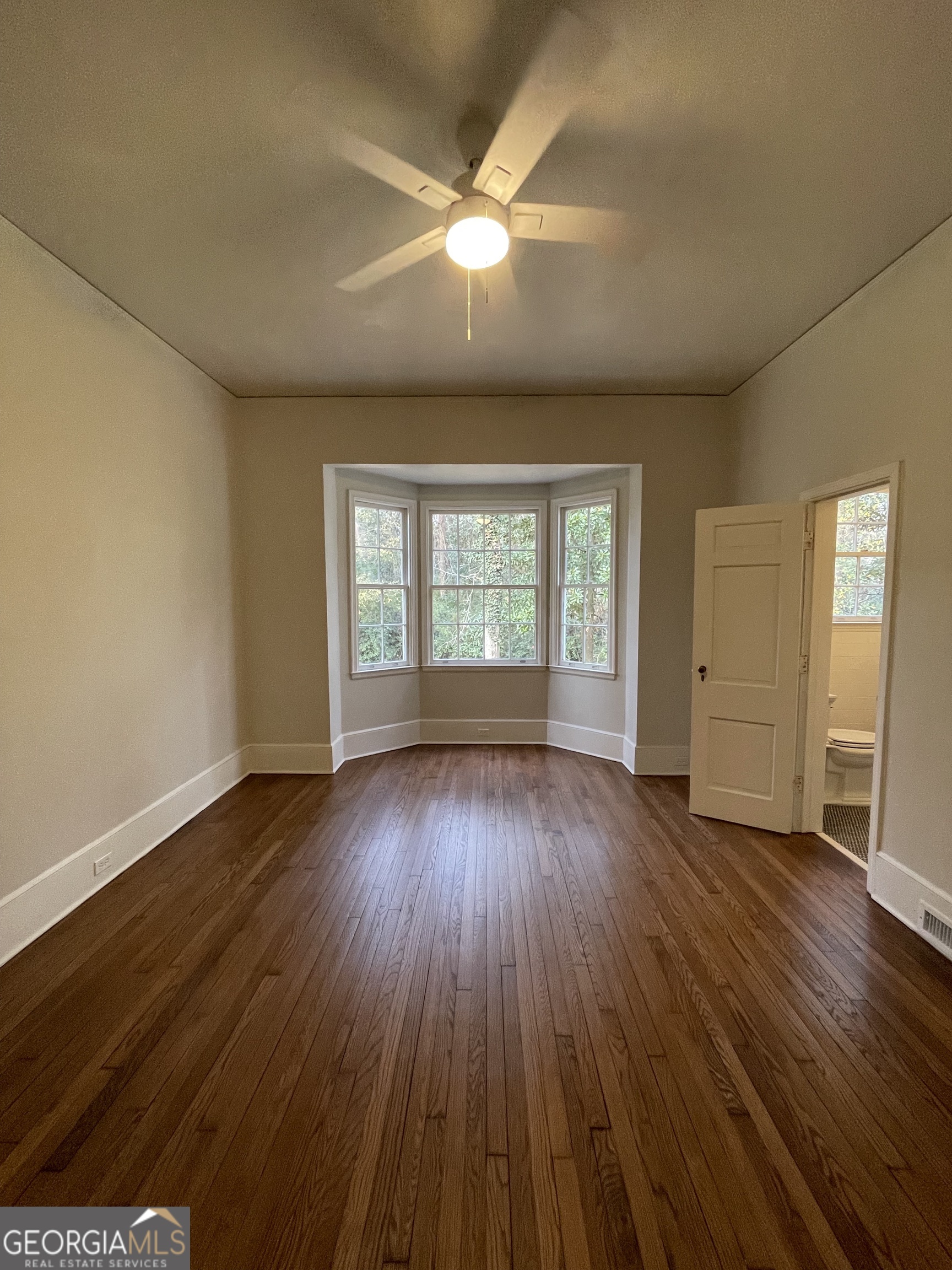 408 Thurston Avenue Thomaston, GA 30286 - Photo 23 of 51 an empty room with wooden floor and windows