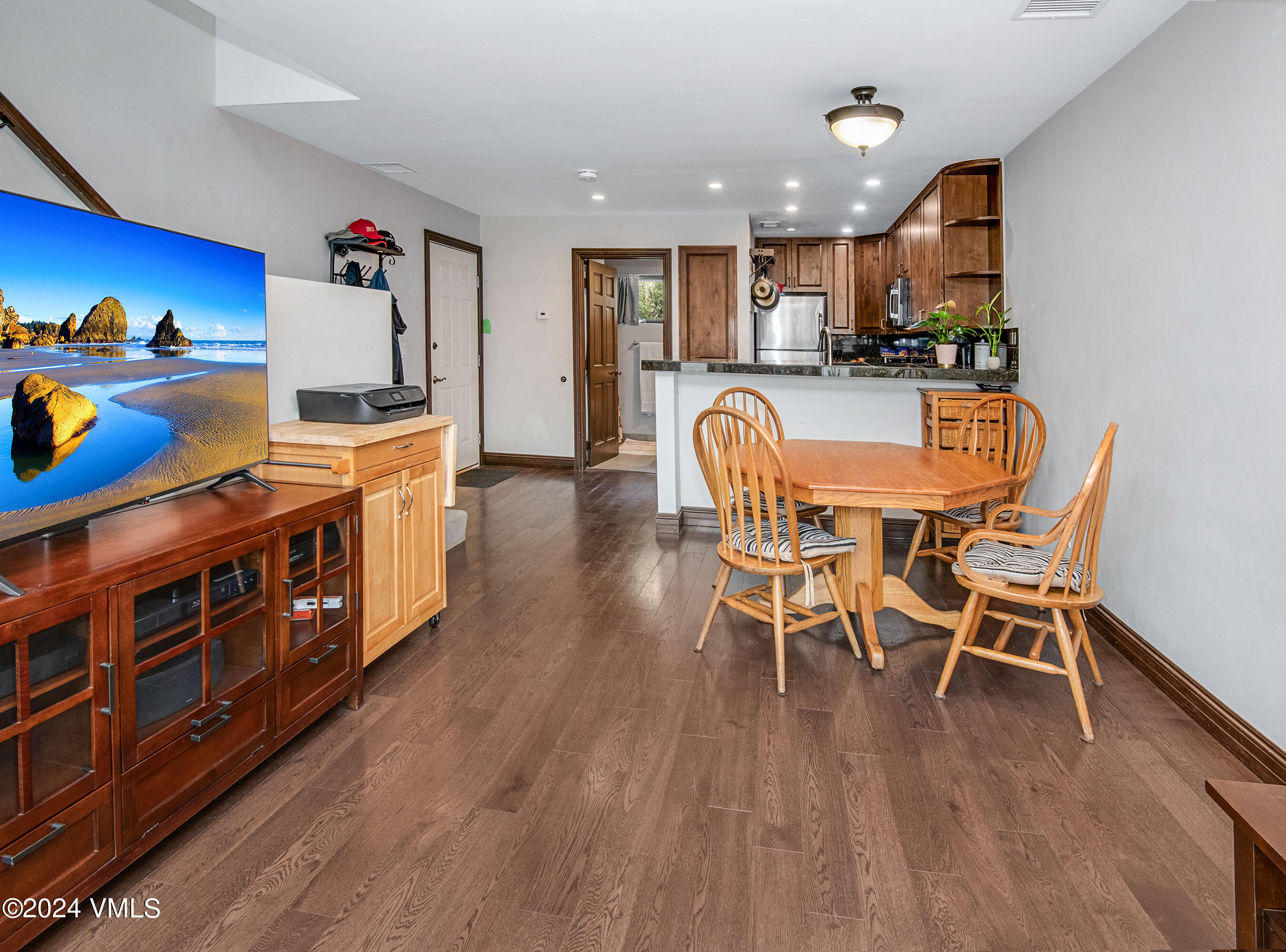600 Nottingham Road, Unit 5 Avon, CO 81620 - Photo 7 of 13 a kitchen with stainless steel appliances granite countertop a table chairs stove and wooden floor