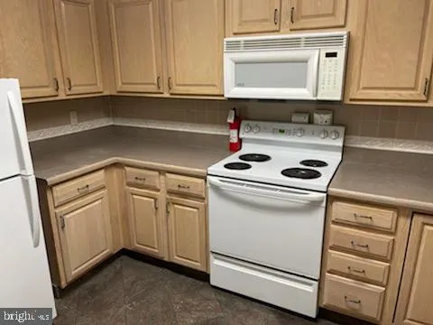 a kitchen with white cabinets and white appliances