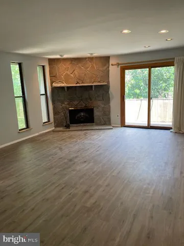 an empty room with windows and fireplace
