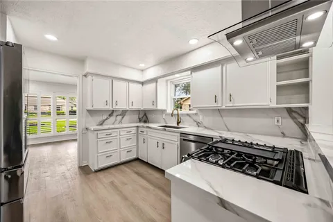 a kitchen with a stove a sink and cabinets