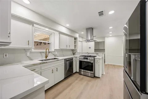 a kitchen with a sink stainless steel appliances and cabinets