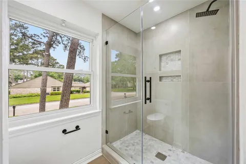 an empty room with wooden floor ceiling fan and windows