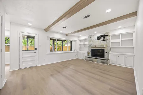 an empty room with windows and fireplace
