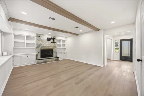 a view of empty room with a fireplace and a window