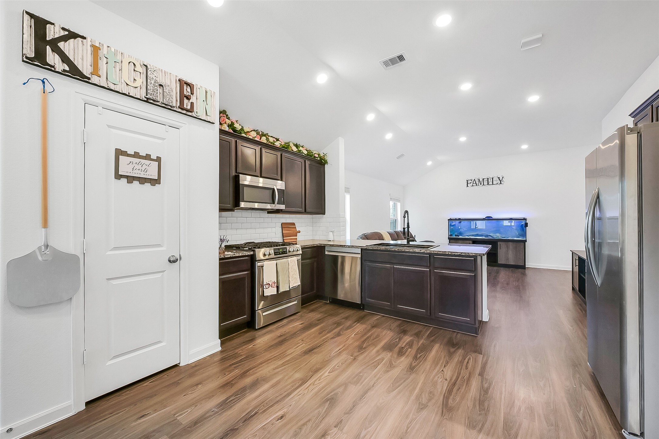 1004 Bulwark Crosby, TX 77532 - Photo 11 of 29 a kitchen with stainless steel appliances kitchen island granite countertop a refrigerator a stove top oven and sink